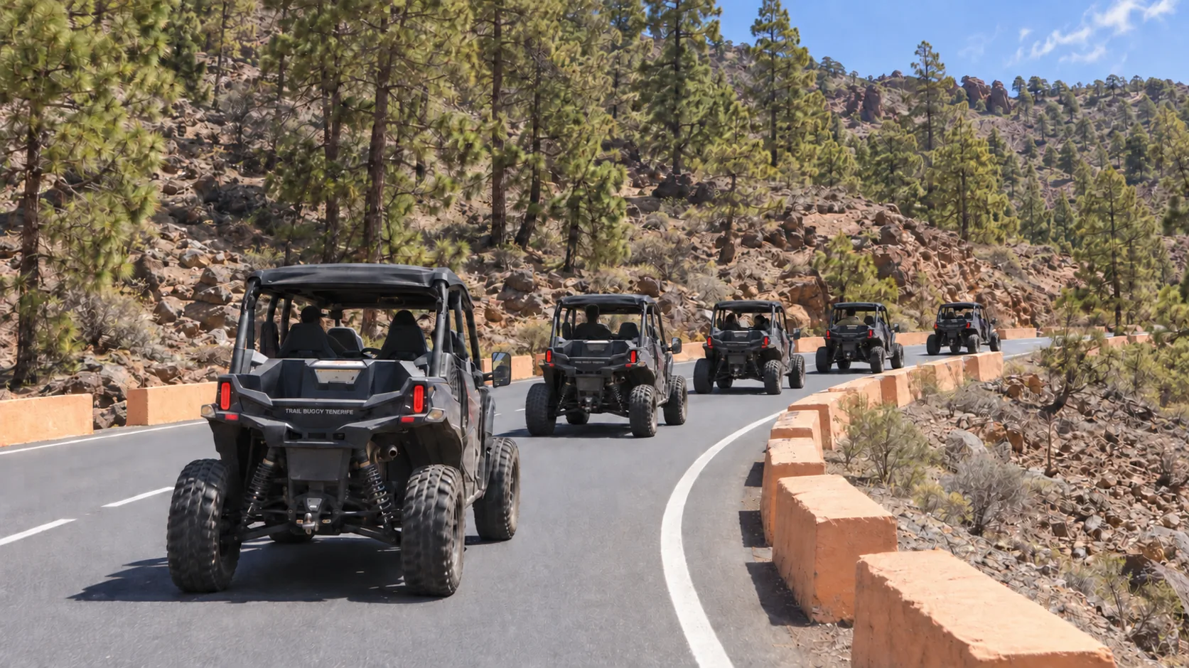 A convoy of buggies driving along a mountain road